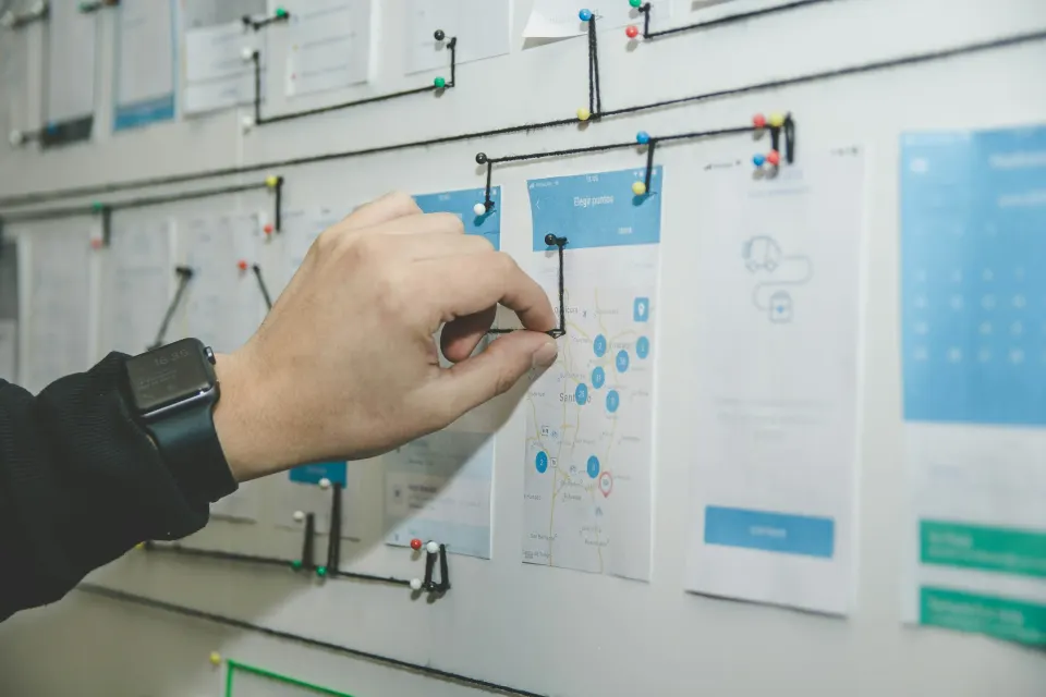 Hand pinning user-flow sketches to a planning wall